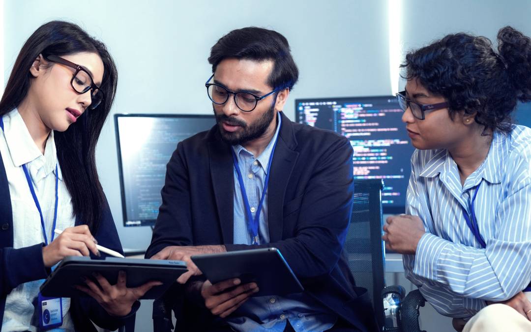 A team of IT professionals typing at their computers in the offi